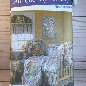 May include: A Simplicity sewing pattern for a nursery with a teddy bear theme. The pattern includes instructions for a crib skirt, a quilt, a pillow, and a valance. The pattern is called "Antique Toy Nursery" and includes instructions for accessories.