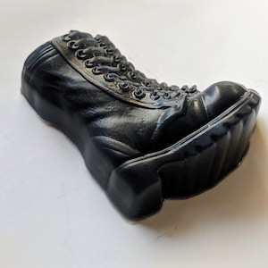 May include: A black rubber boot with laces. The boot is made to look like a real boot.