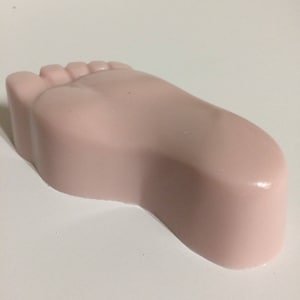 May include: A pink foot-shaped soap bar.
