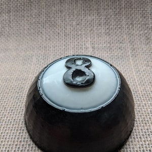 May include: Black and white 8 ball with a white background and a black rim. The 8 is in black with a white outline.