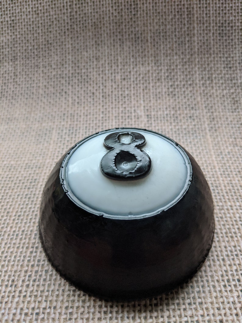 May include: Black and white 8 ball with a white background and a black rim. The 8 is in black with a white outline.