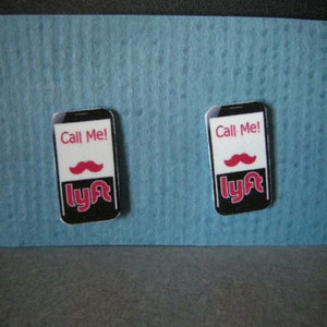 May include: Two black and white phone-shaped stickers with the text "Call Me!" and the Lyft logo in pink. A pink mustache is above the Lyft logo on each sticker.