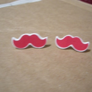 May include: A pair of red and white mustache shaped earrings.