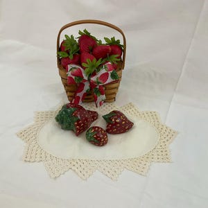May include: A white ceramic mug with a black handle and the text "But First, Coffee" in a bold, black font. The mug is set against a blurred background, highlighting its clean design.