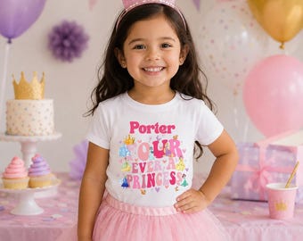Puede incluir: Una niña pequeña lleva una camiseta blanca con el texto "Porter Our Ever A Princess" en rosa y otros colores, un tutú rosa y una corona rosa. El fondo incluye globos, una tarta y decoraciones de fiesta.
