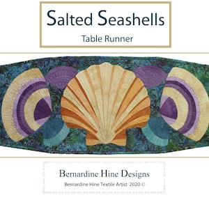 May include: A teal blue table runner with a large seashell design in the center. The seashell is made of beige, orange, and brown fabric. The runner is surrounded by smaller seashells in shades of purple, beige, and teal.