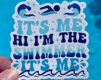 May include: White sticker with blue and white text that reads "It's Me Hi I'm The Swimmer It's Me". The sticker has a blue swimmer silhouette and blue wave designs.