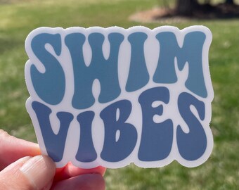 May include: A blue and white sticker with the text "Swim Vibes" in a retro font.