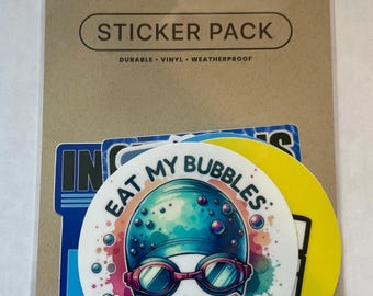 May include: A sticker pack with the words "STICKER PACK" and the words "DURABLE • VINYL • WEATHERPROOF" printed on the packaging. The pack contains several stickers, including one that says "EAT MY BUBBLES".