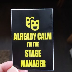 May include: Black and yellow sticker with two yellow theater masks and the text "ALREADY CALM I'M THE STAGE MANAGER".
