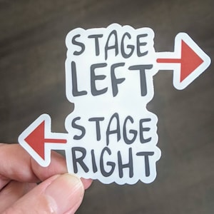 May include: White sticker with black text that reads "Stage Left" with a red arrow pointing right and "Stage Right" with a red arrow pointing left.
