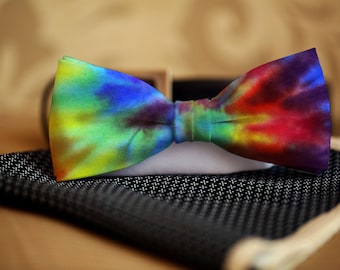 May include: A colourful tie-dye bow tie with shades of blue, green, yellow, red, and purple.
