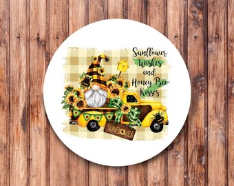 Op de afbeelding: Een witte ronde sticker met een gele vrachtwagen die een dwerg en zonnebloemen vervoert. De vrachtwagen heeft een bord met de tekst "Sunflower". De tekst op de sticker luidt "Sunflower Wishes and Honey Bee Kisses".