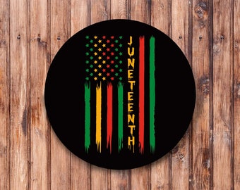 May include: A black circle with a red, yellow, and green American flag design. The flag has stars in the top left corner and the word "Juneteenth" written vertically in yellow letters.
