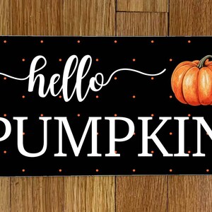 May include: Black and white sign with orange polka dots and the text "hello pumpkin" with a small orange pumpkin illustration.