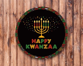 May include: A round, black and gold Kwanzaa sign with a traditional kinara, seven candles, and the text "Happy Kwanzaa". The sign is surrounded by a colorful border with geometric patterns.