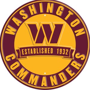 Puede incluir: Un letrero metálico redondo con el logotipo de los Washington Commanders. El letrero es principalmente burdeos y dorado, con el nombre del equipo y "Established 1932" en un lugar destacado. El logotipo es una "W" estilizada en burdeos.