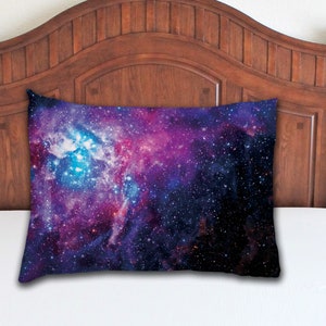 Op de afbeelding: Een kussensloop in paars, blauw en zwart met een galaxy print met sterren en nevels.