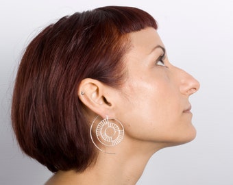 Silver earrings. Earrings hook circular shape. Silver wire drawing a labyrinth. Geometric shape. Wheel earring. Gears