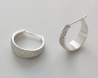 Small hoop type silver earrings. Earrings with irregular texture of white and shiny silver. Sea erosion texture on the stone.
