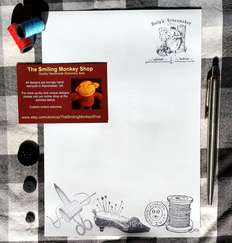 Puede incluir: Un juego de papeler&iacute;a con una hoja de papel blanca con un dise&ntilde;o de costura impreso, una tarjeta de visita y un bol&iacute;grafo. La tarjeta de visita dice "The Smiling Monkey Shop" e incluye una peque&ntilde;a ilustraci&oacute;n de un mono. Tambi&eacute;n se incluyen carretes de hilo y botones.