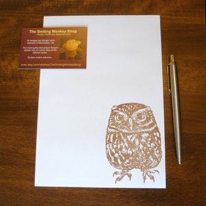 May include: A brown and white owl illustration printed on a white card. The card is part of a set of stationery featuring hand-stamped designs from The Smiling Monkey Shop. The shop's website address is included on the card.