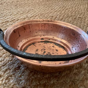 May include: A white ceramic mug with a black handle and the text "But First, Coffee" in a black, bold font. The mug is sitting on a wooden surface. The mug is approximately 4 inches tall.