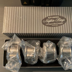 Cuatro servilleteros de peltre FB Roger’s Silver Company en su caja original, usados, fabricados en Taunton, Massachusetts. Cuatro servilleteros de peltre