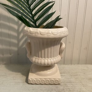 Jarrón antiguo de cerámica color marfil, estilo urna, marcado en la base.