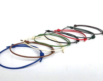 May include: A set of eight leather bracelets in various colors, including blue, brown, cream, green, black, and red. The bracelets are tied with a knot at the end.
