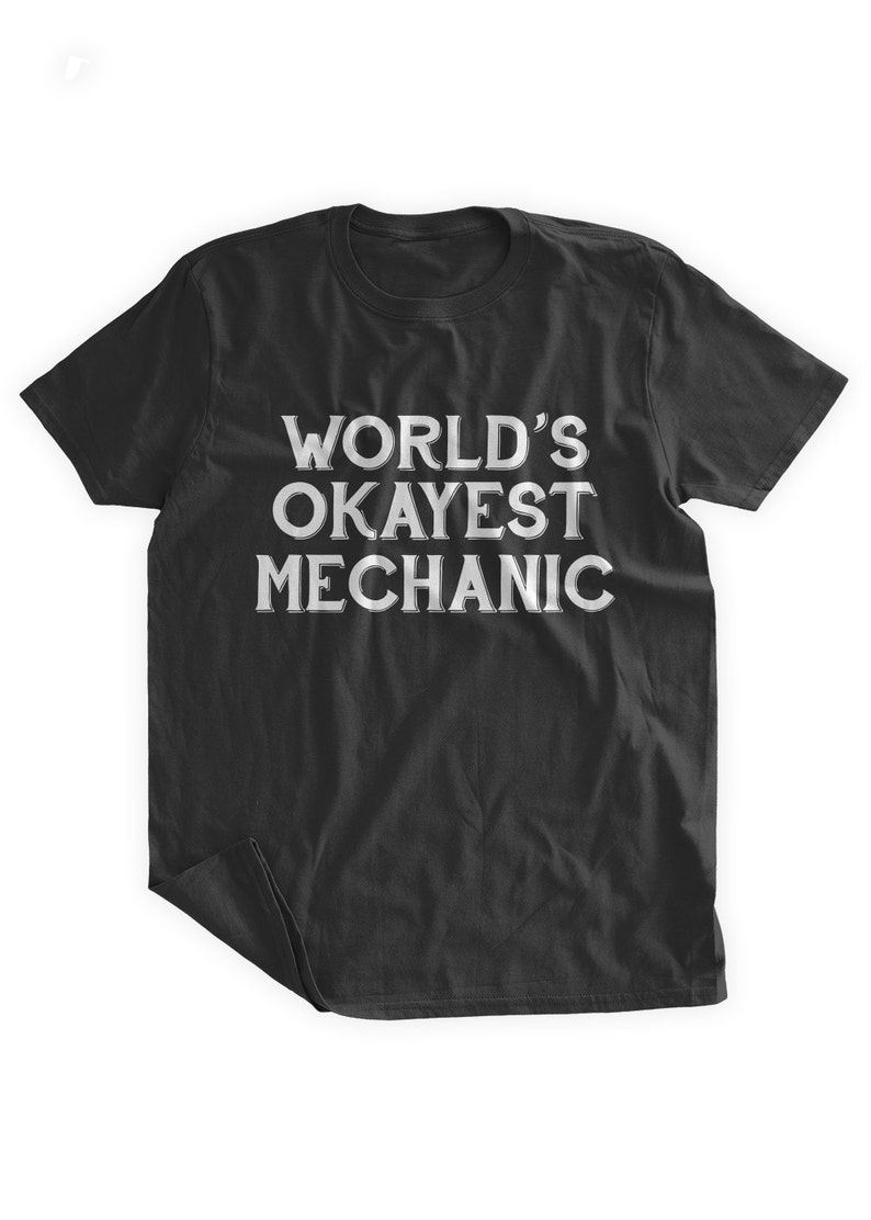 May include: Black t-shirt with white text that reads "WORLD'S OKAYEST MECHANIC".