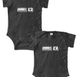 May include: Two black baby onesies with white computer keyboard keys printed on them. The onesies say "Command" and have the "V" and "C" keys printed on them.