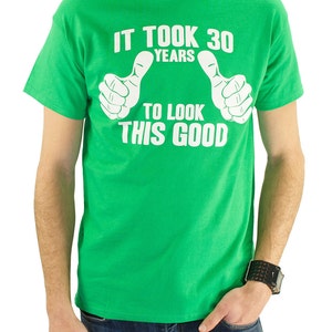 May include: Green t-shirt with white text that reads "It took 30 years to look this good" with two thumbs up symbols.