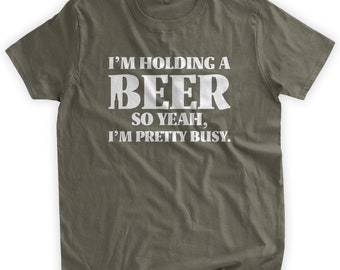 Könnte beinhalten: Ein grünes T-Shirt mit weißem Text, der lautet: "Ich halte ein Bier, also ja, ich bin ziemlich beschäftigt."