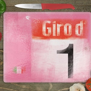 Może przedstawiać: Różowa szklana deska do krojenia z czerwono-białym nadrukiem "Giro d' 1".