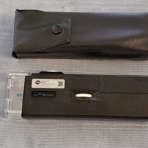 May include: A black pocket microscope with a clear lens and a 10X magnification. It comes with a black leather case.