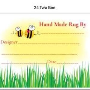 May include: A decorative tag with the text "Hand Made Rug By" and space for a designer's name and date. The tag features two cartoon bees and green grass at the bottom. The text "24 Two Bee" is at the top.