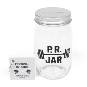 PR Jar™ for Personal Records, Weightlifting, Powerlifting, Crossfit. Jar is clear. Design is black. Coin slot lid is silver. Notepad included. The PR Jar™ is an original FitFizz creation that makes an excellent gift for yourself or any lifter.