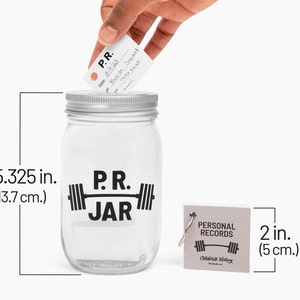 PR Jar™ for Personal Records, Weightlifting, Powerlifting, Crossfit. Jar is clear. Design is black. Coin slot lid is silver. Notepad included. The PR Jar™ is an original FitFizz creation that makes an excellent gift for yourself or any lifter.