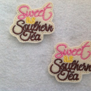 May include: Two felt patches with the text "Sweet as Southern Tea" in pink and brown lettering. The patches are on a white background.