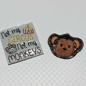May include: White fabric patch with the text "Not my circus, not my monkeys" and a small embroidered image of a monkey. A separate brown embroidered monkey face patch.