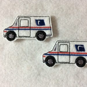 May include: Two white mail trucks with blue and red stripes and a blue "USPS" logo. The trucks are embroidered and are approximately 2 inches long.
