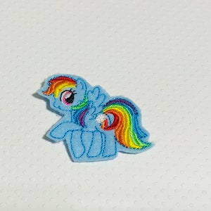 May include: A blue and rainbow embroidered patch of a cartoon pony with a rainbow mane and tail.