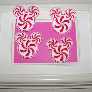 May include: Four red and white peppermint candy cane Mickey Mouse head shaped iron-on patches.