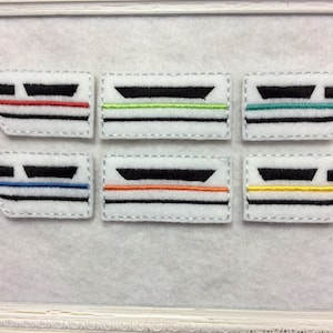 May include: Six felt patches depicting a stylized train with different colored stripes. The stripes are red, green, blue, orange, yellow, and teal.