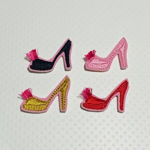 May include: Four embroidered iron-on patches of high-heeled shoes with pink, red, black, and gold fabric. Each shoe has a pink feather detail.