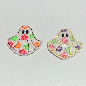 May include: Two white felt ghost appliques with embroidered details. One ghost has pink, orange, and green flowers. The other ghost has purple, green, and yellow flowers.