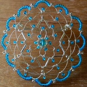 May include: A silver wire and blue bead kippah, a traditional Jewish head covering.
