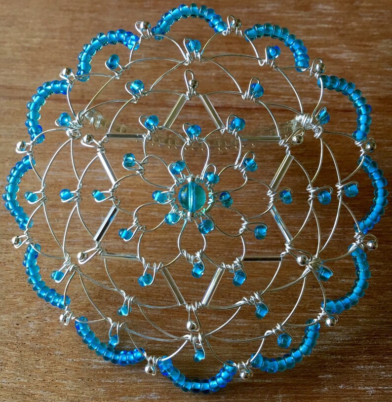 May include: A silver wire and blue bead kippah, a traditional Jewish head covering.