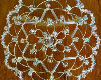 May include: A silver wire and crystal beaded kippah, or yarmulke, with a star of David design. The kippah is decorated with clear iridescent crystals.